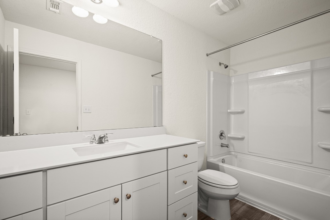 109 Gray Fox Loop Hutto, TX 78634 - Photo 18 of 28 Full bath with bathing tub / shower combination, vanity, and dark wood-style floors