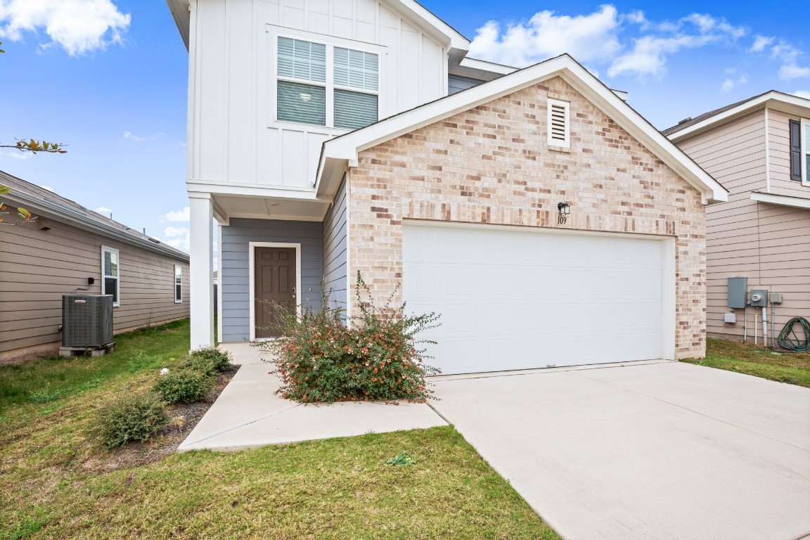 109 Gray Fox Loop Hutto, TX 78634 - Photo 22 of 28 View of front of property with board and batten siding, brick siding, driveway, and a front lawn