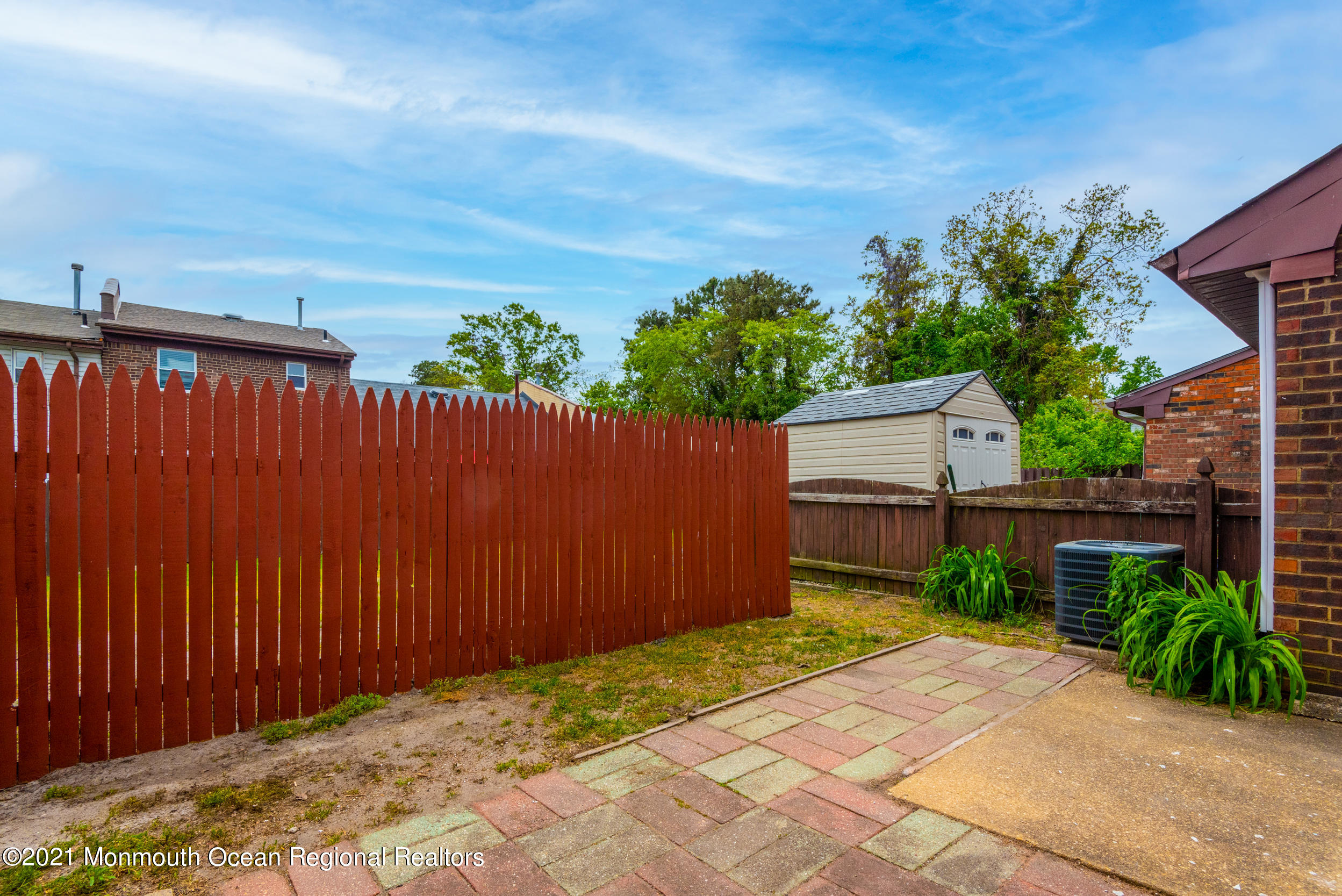 48 Greenwood Loop Road Brick, NJ 08724 - Photo 17 of 20 a backyard of a house with plants and wooden fence