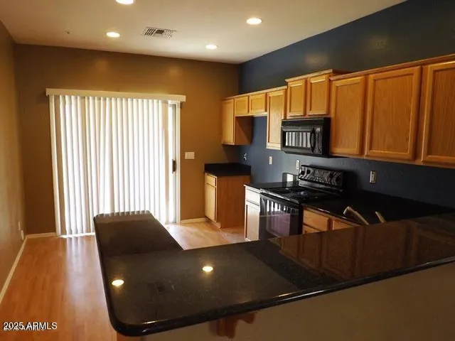 a kitchen with stainless steel appliances granite countertop a refrigerator a stove top oven a sink and dishwasher