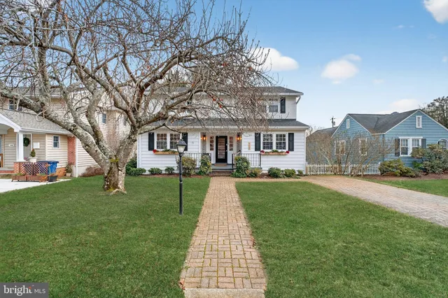 a front view of a house with a yard and trees