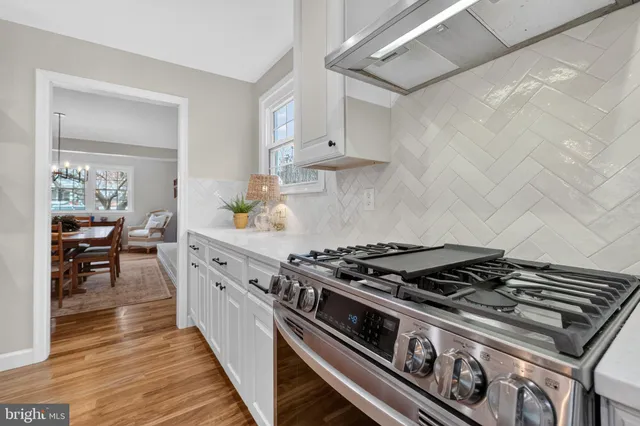 a kitchen with a stove and wooden floor