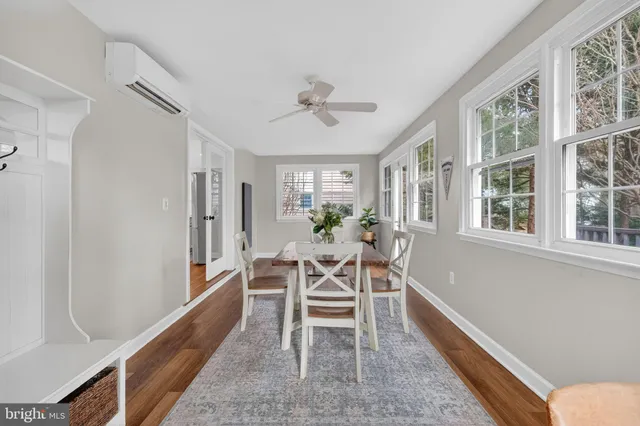 a dining room with furniture a chandelier and wooden floor