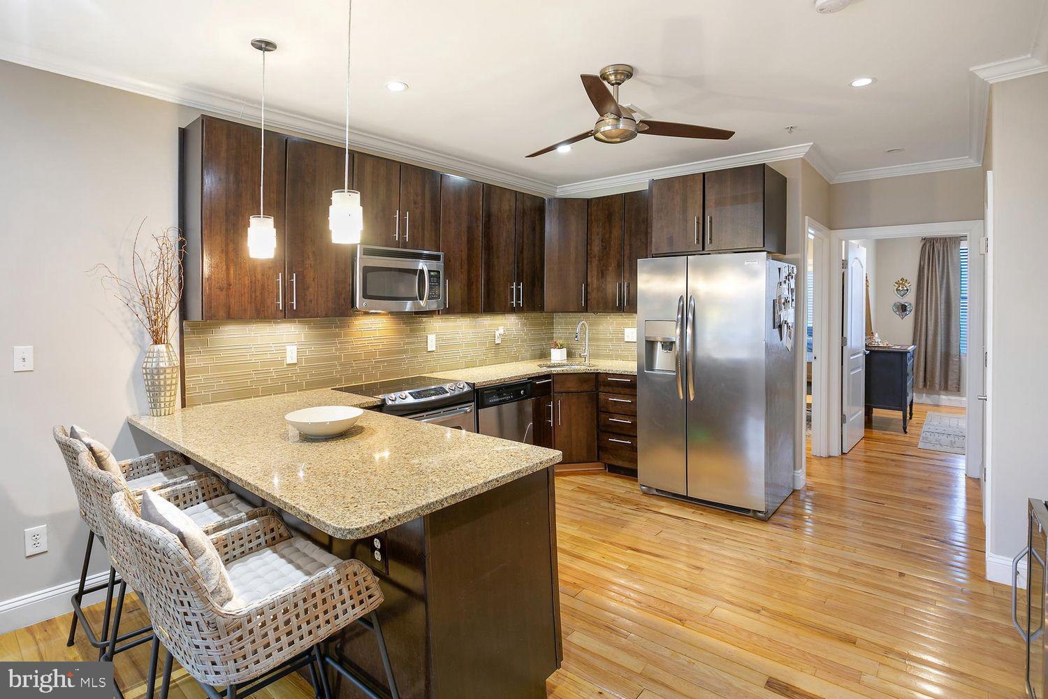2650 15th Street Northwest, Unit 2 Washington, DC 20009 - Photo 9 of 25 a kitchen with a table chairs refrigerator and microwave