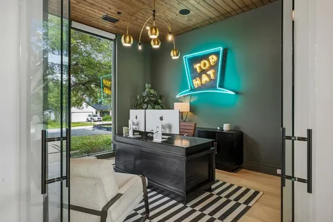 a room with chandelier fan and a wooden floor