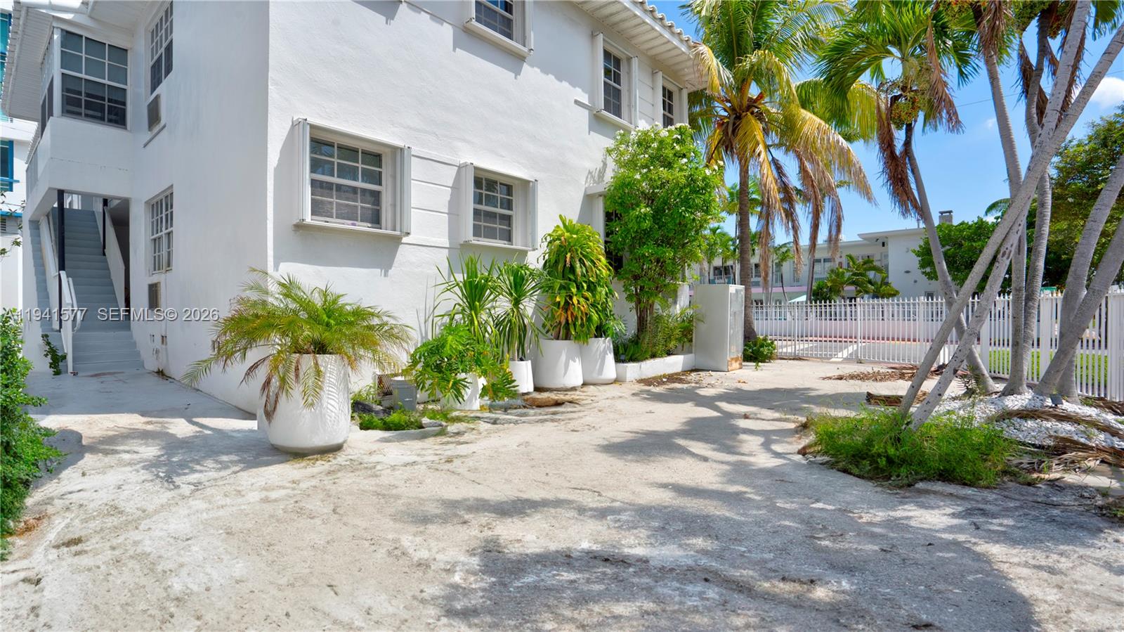 7611 Harding Avenue, Unit 7 Miami Beach, FL 33141 - Photo 3 of 11 a view of a backyard with potted plants and palm trees