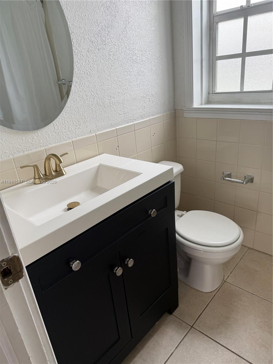 7611 Harding Avenue, Unit 7 Miami Beach, FL 33141 - Photo 4 of 9 a bathroom with a sink vanity and a toilet