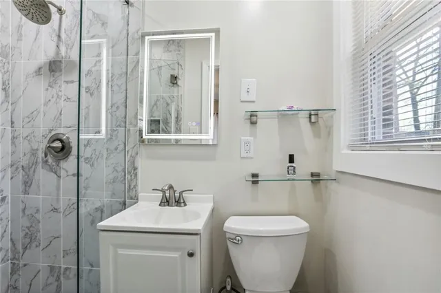 a bathroom with a toilet a sink and mirror