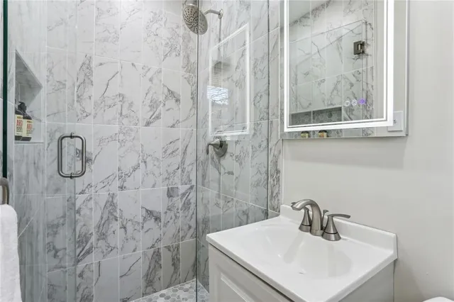 a bathroom with a sink mirror and shower