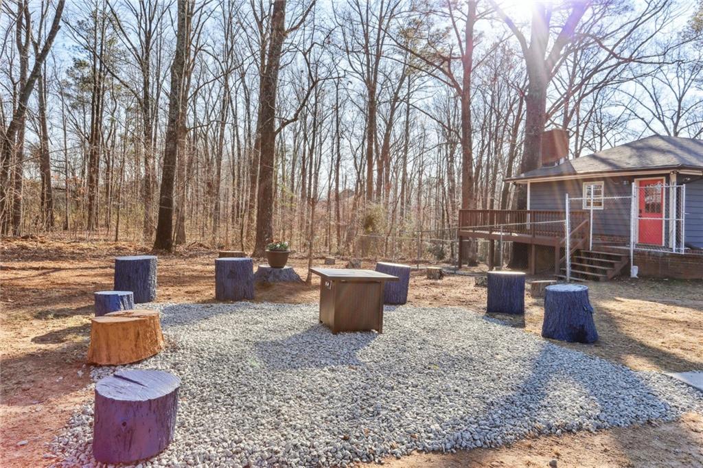 4667 Glore Road Southwest Mableton, GA 30126 - Photo 27 of 46 a view of a backyard with table and chairs potted plants and large tree