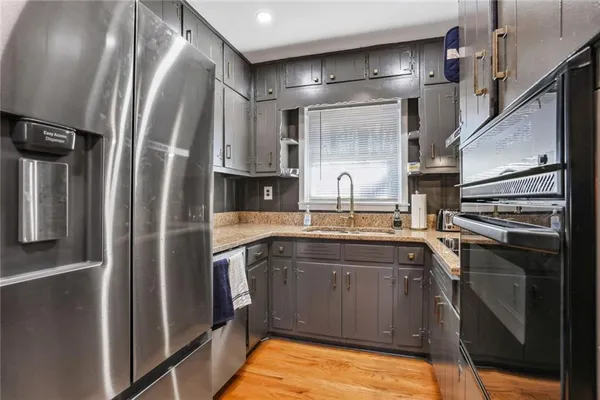 a kitchen with stainless steel appliances granite countertop a refrigerator and a sink