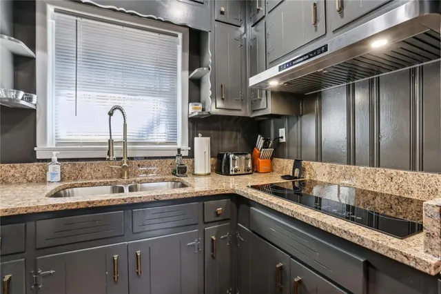 a kitchen with stainless steel appliances granite countertop a sink and wooden cabinets