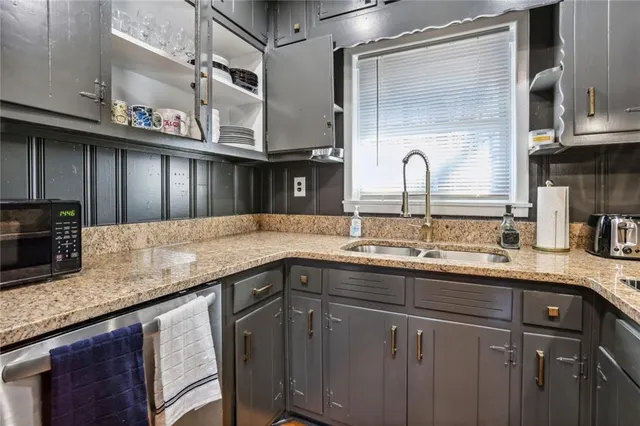 a kitchen with stainless steel appliances granite countertop a sink a stove and cabinets