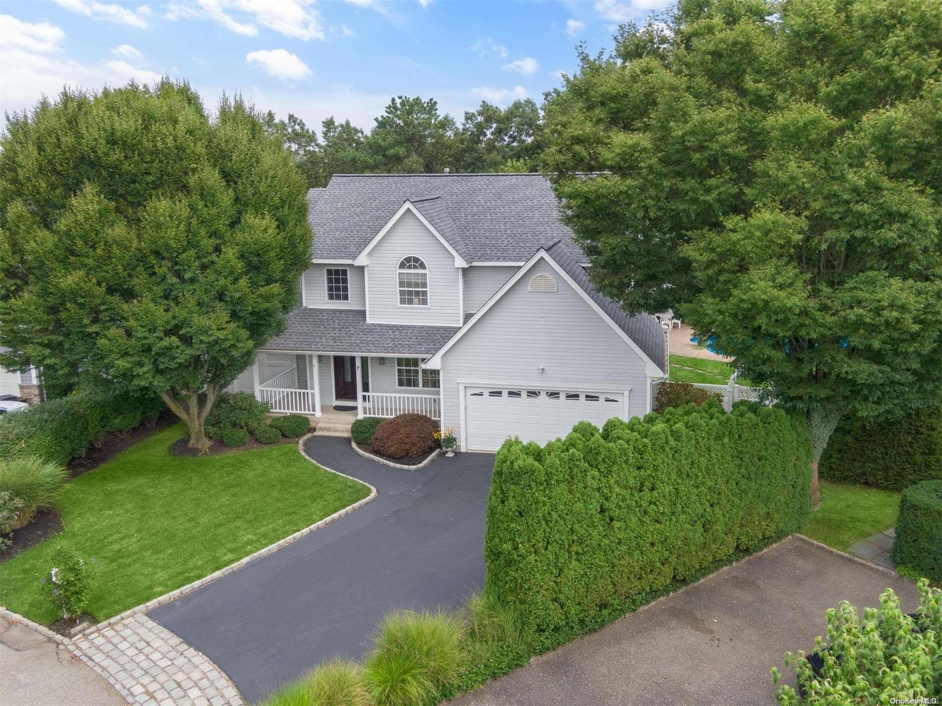 a front view of a house with yard and green space