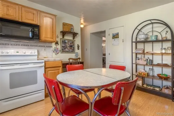 a living room with stainless steel appliances furniture a dining table and kitchen view