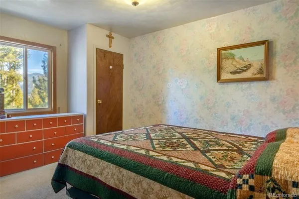 a bedroom with a bed and a large mirror