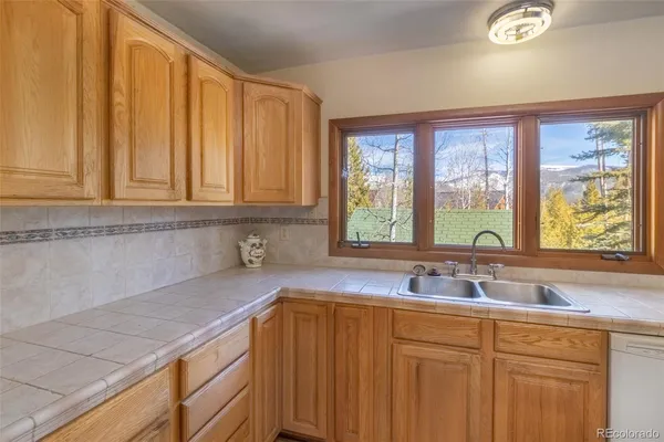a kitchen with granite countertop a sink a window and cabinets