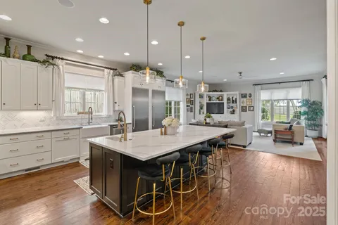a large kitchen with kitchen island a island a sink a stove and wooden floor
