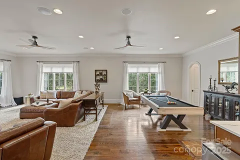 a living room with furniture kitchen view and large windows