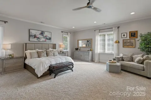 a spacious bedroom with a bed a couch and a window