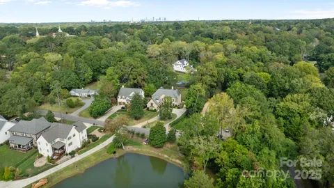 an aerial view of residential houses with outdoor space and trees