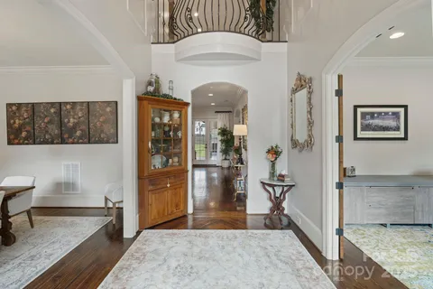 a view of a hallway with wooden floor and a living room