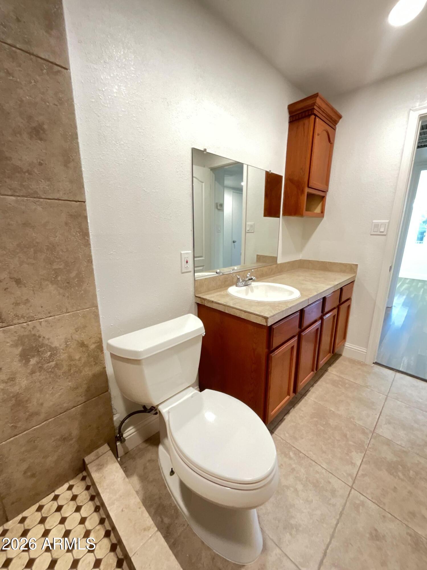 8052 West Pierson Street Phoenix, AZ 85033 - Photo 15 of 36 a bathroom with a sink a toilet and mirror
