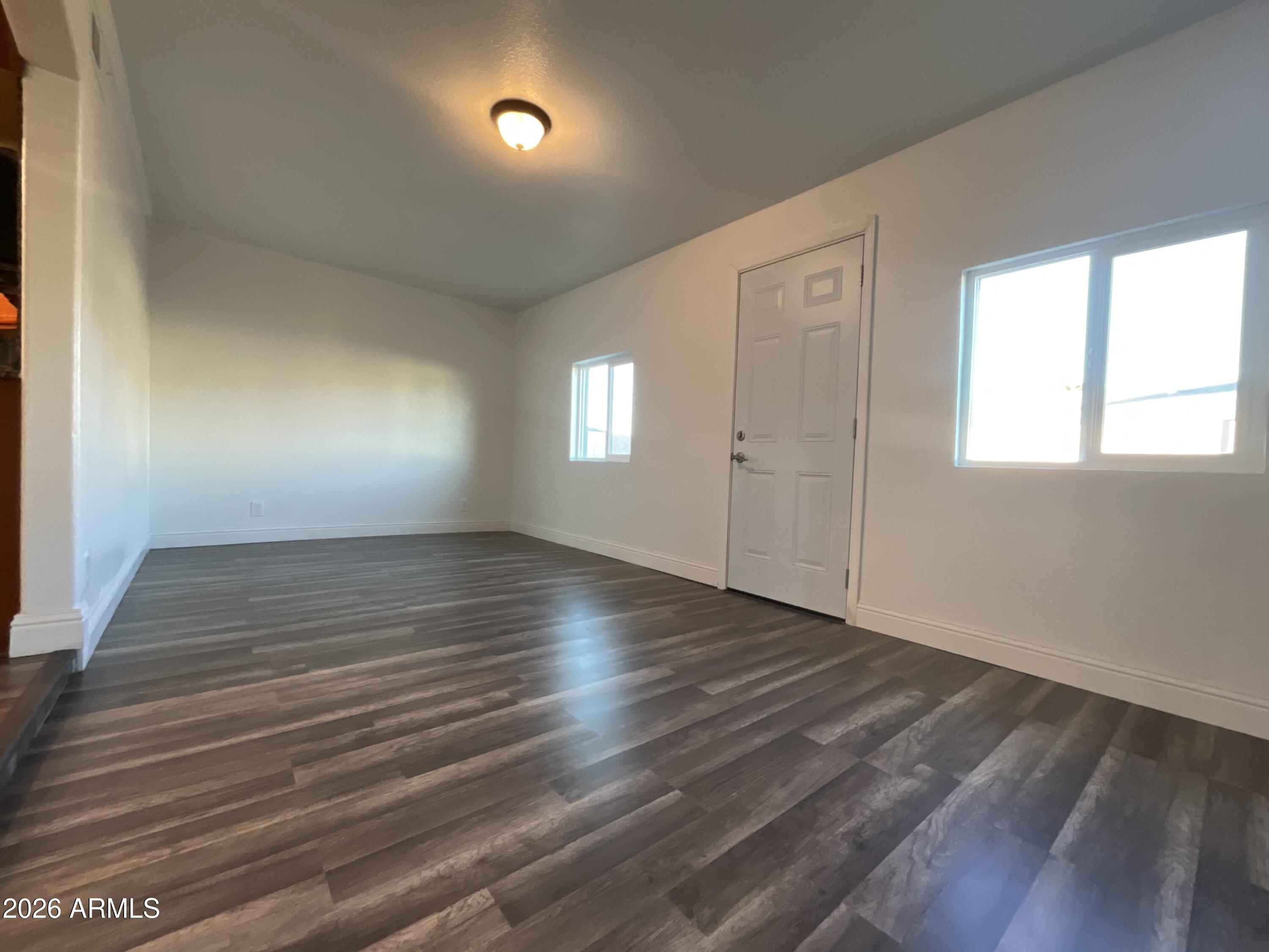 8052 West Pierson Street Phoenix, AZ 85033 - Photo 26 of 36 an empty room with wooden floor and windows