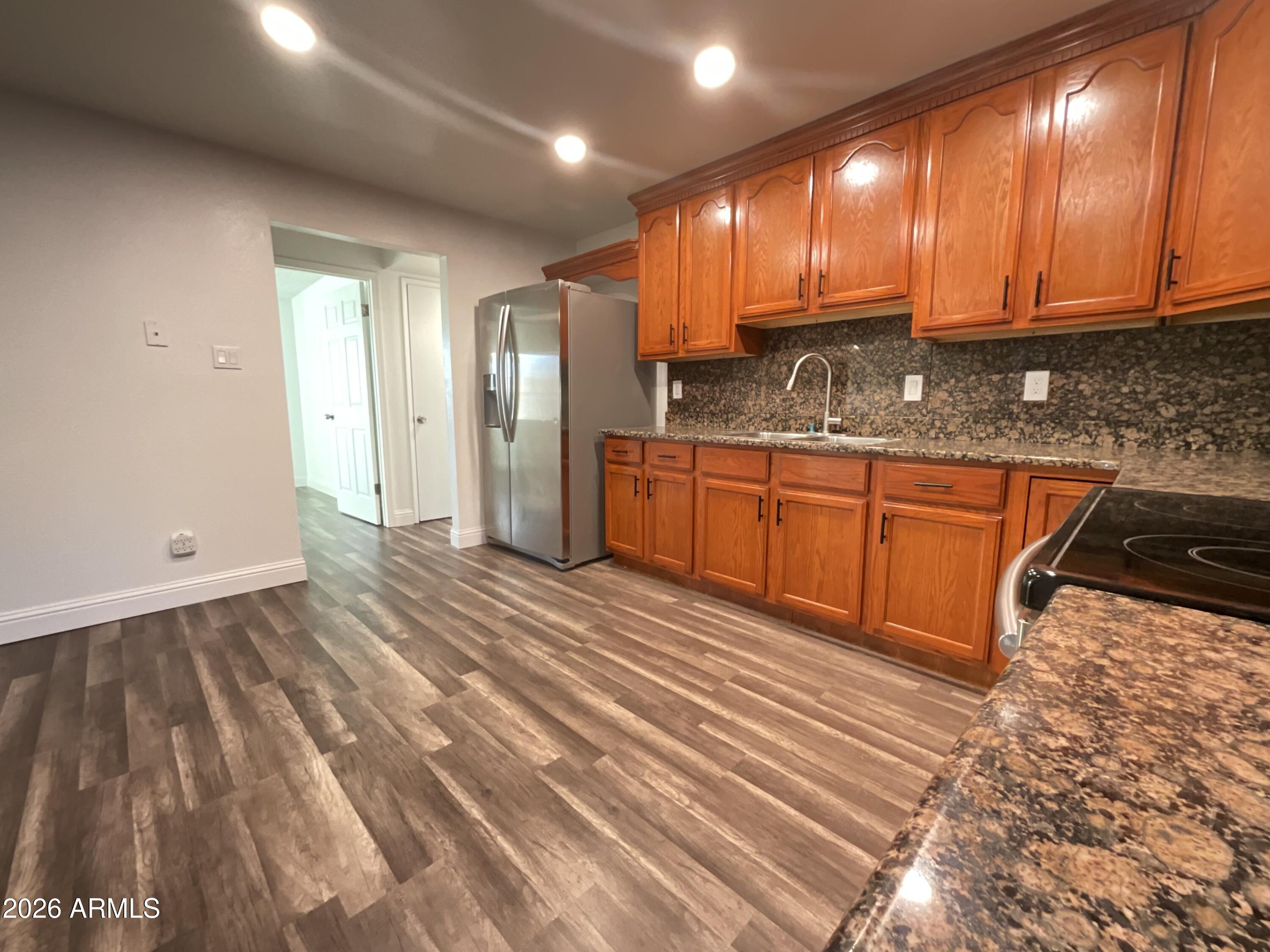 8052 West Pierson Street Phoenix, AZ 85033 - Photo 32 of 36 a large kitchen with stainless steel appliances granite countertop a sink stove and cabinets