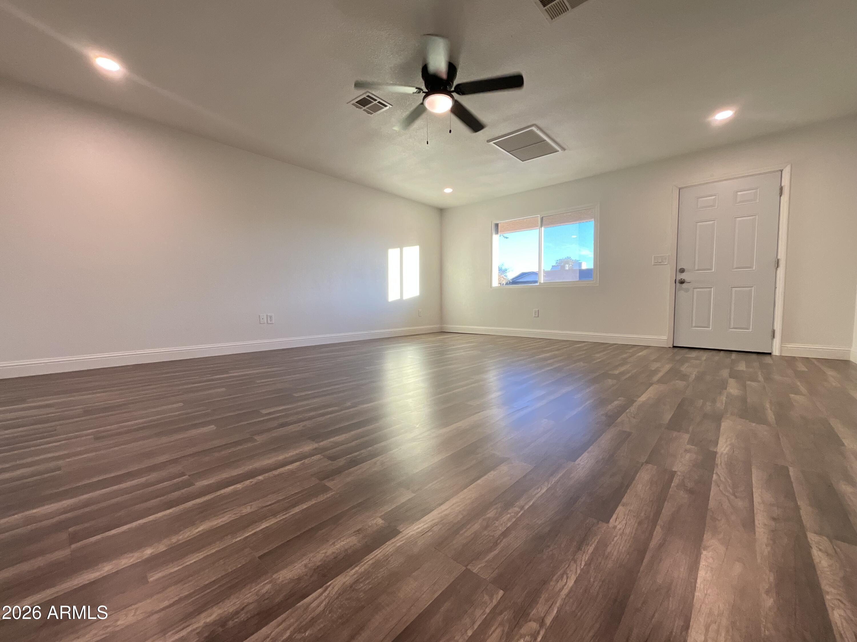8052 West Pierson Street Phoenix, AZ 85033 - Photo 33 of 36 an empty room with wooden floor and windows