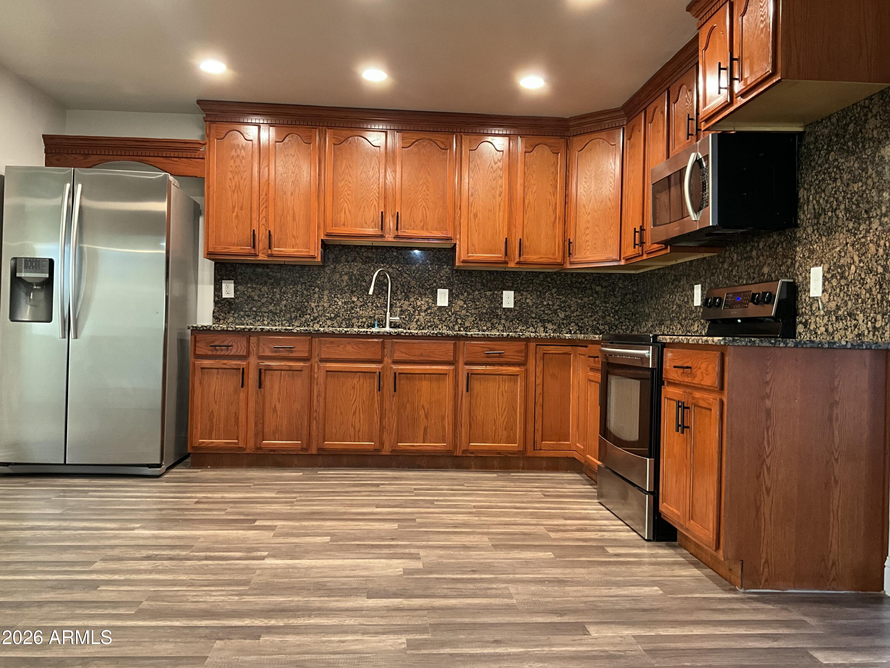 8052 West Pierson Street Phoenix, AZ 85033 - Photo 35 of 36 a kitchen with stainless steel appliances granite countertop a sink a stove and a refrigerator