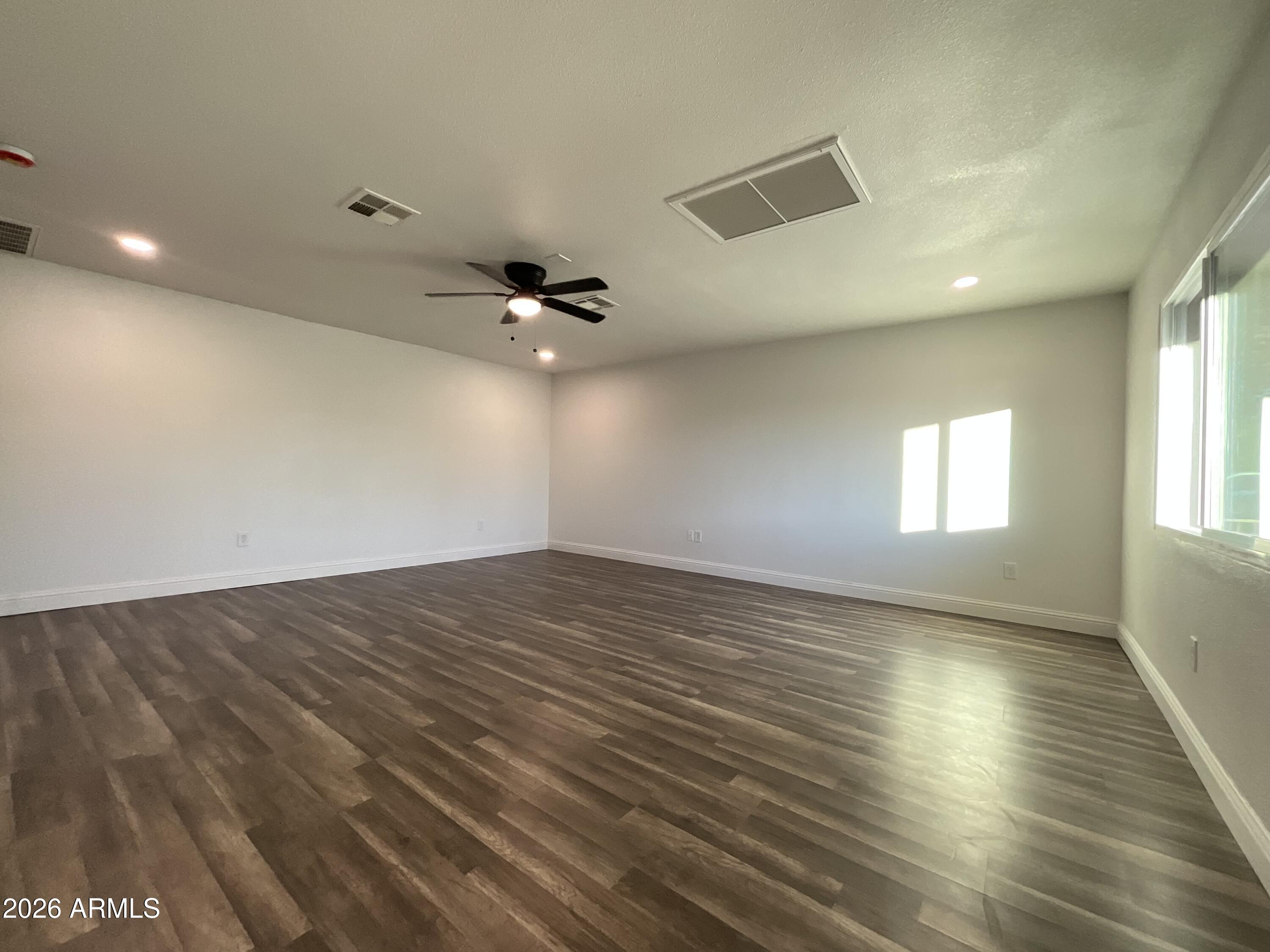 8052 West Pierson Street Phoenix, AZ 85033 - Photo 36 of 36 an empty room with wooden floor and windows