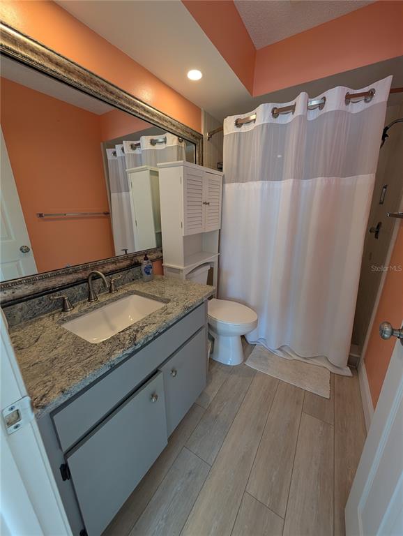 8161 Braddock Circle, Unit 1 Port Richey, FL 34668 - Photo 13 of 27 a bathroom with a granite countertop sink toilet and shower
