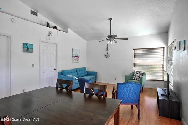 a living room with furniture a table and wooden floor