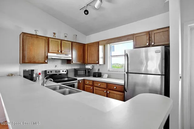 a kitchen with stainless steel appliances a refrigerator sink microwave and cabinets