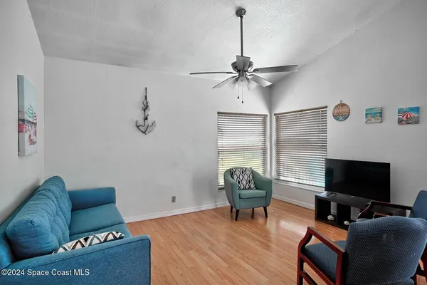 a living room with furniture a flat screen tv and a window