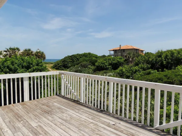 a balcony with wooden floor and fence