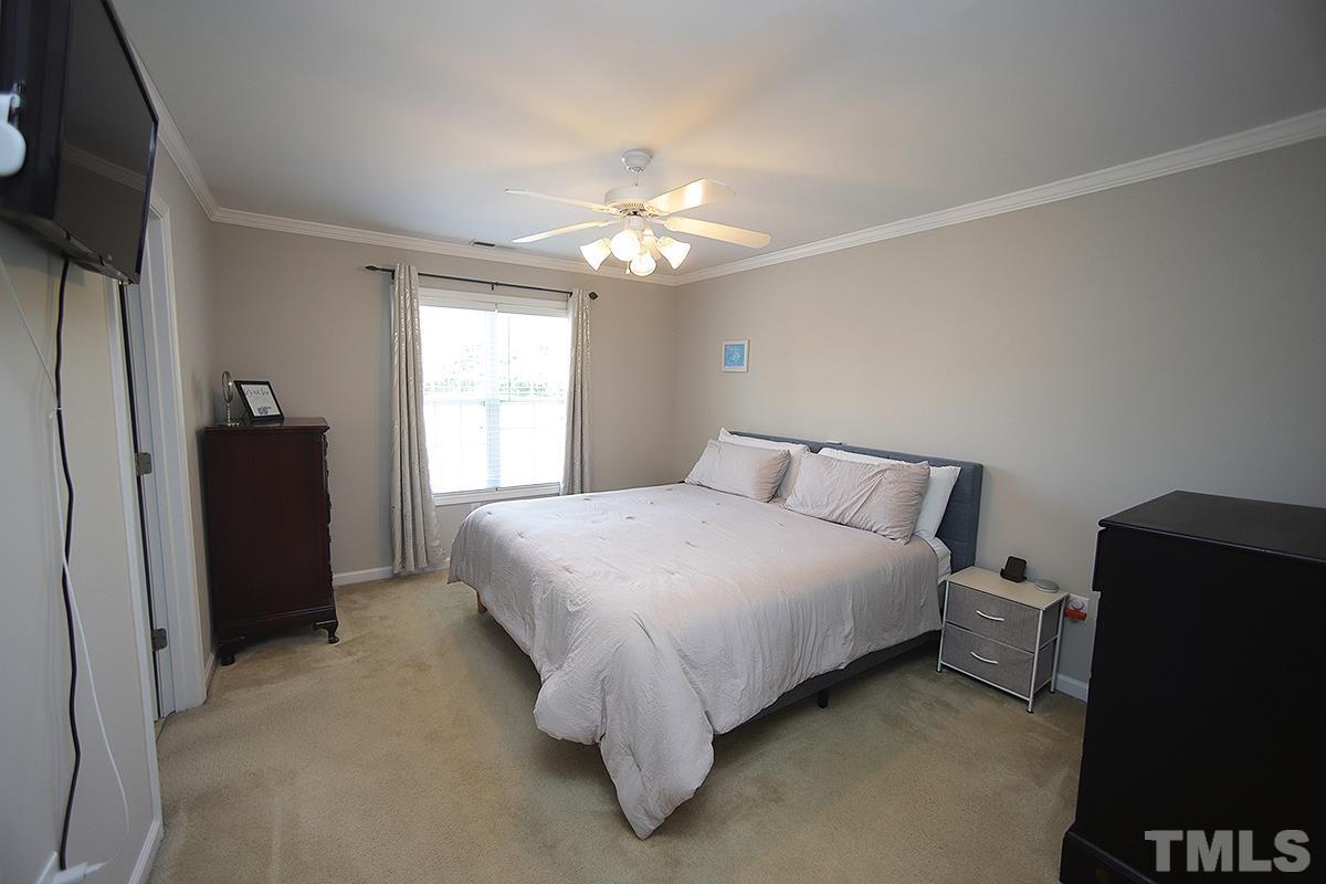2656 Andover Glen Road Raleigh, NC 27604 - Photo 10 of 18 a spacious bedroom with a bed and a chandelier