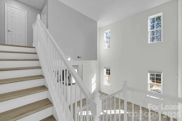 a view of staircase with lots of frames on wall and a window