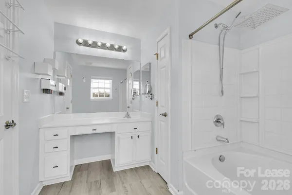 a spacious bathroom with a tub sink and mirror