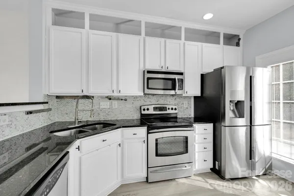 a kitchen with cabinets stainless steel appliances and a counter space