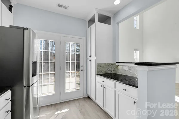 a kitchen with granite countertop a refrigerator and a sink