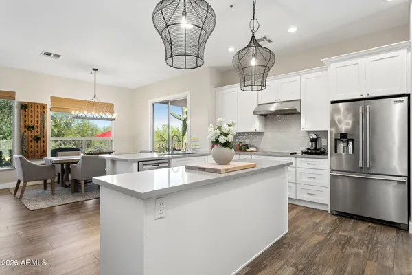 a kitchen with stainless steel appliances granite countertop a kitchen island a stove a table and chairs