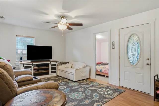 a living room with furniture a flat screen tv and a window