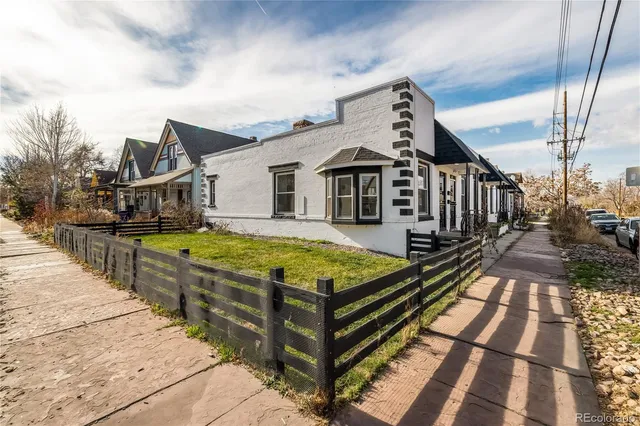 a view of a house with wooden floor next to a yard