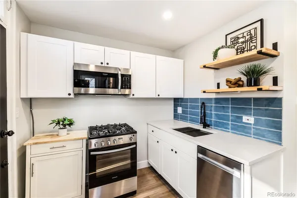 a kitchen with stainless steel appliances a stove a microwave and cabinets