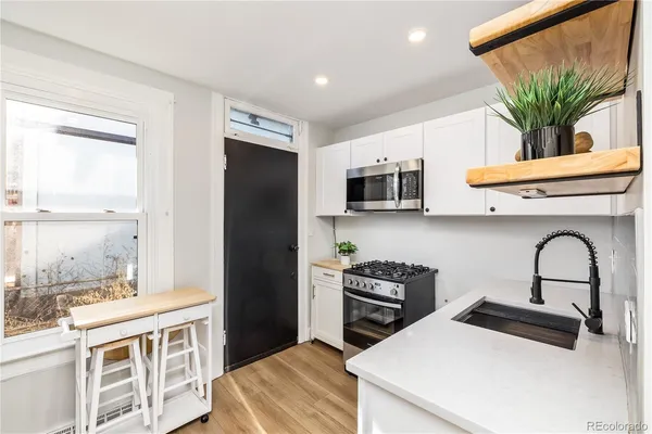a kitchen with stainless steel appliances kitchen island granite countertop a refrigerator a stove a sink and a microwave