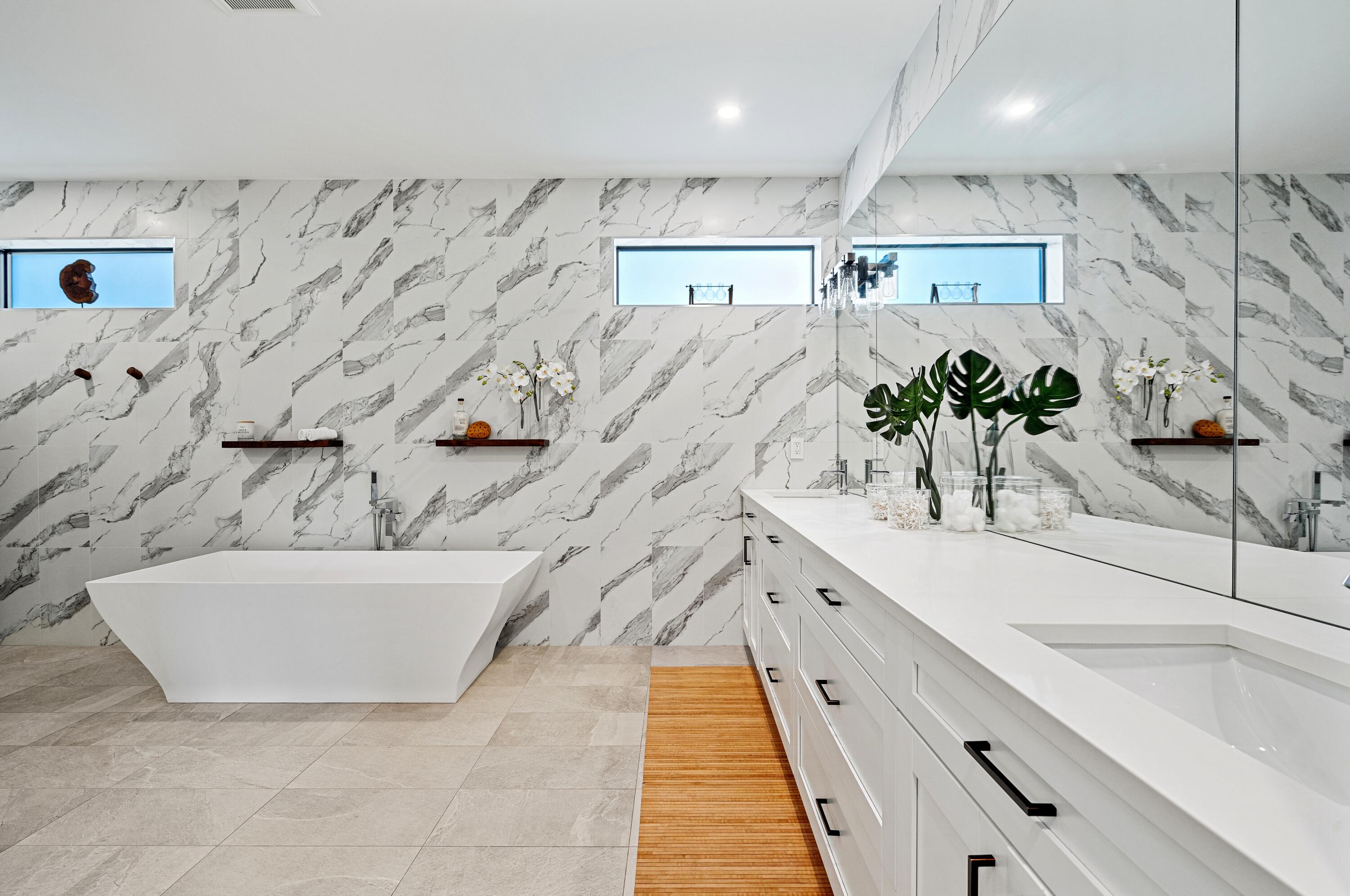 709 Northwest 6th Drive Boca Raton, FL 33486 - Photo 19 of 45 a large white kitchen with kitchen island a potted plant on the counter and a sink