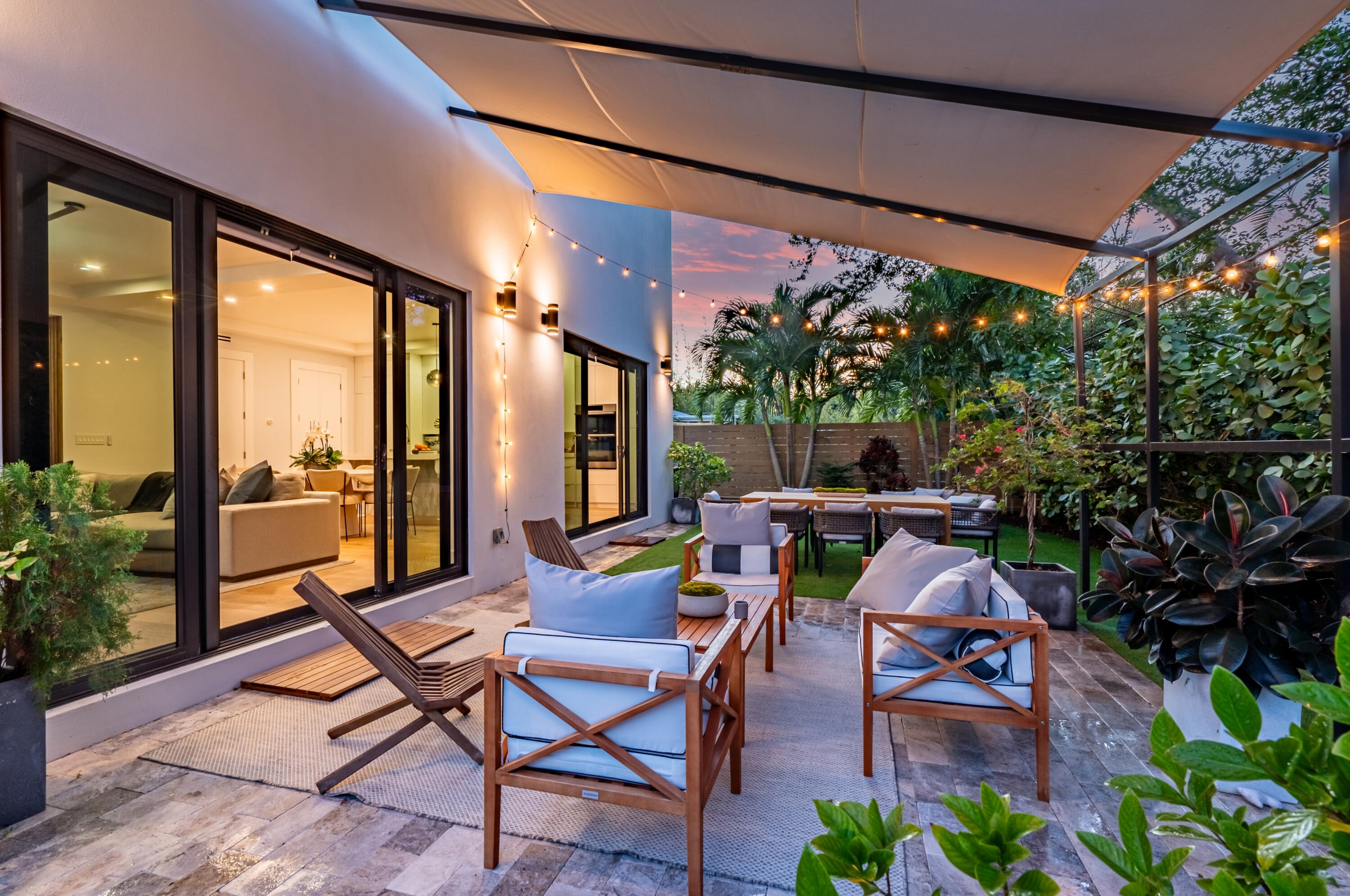 709 Northwest 6th Drive Boca Raton, FL 33486 - Photo 35 of 45 a view of a patio with table and chairs potted plants and floor to ceiling window
