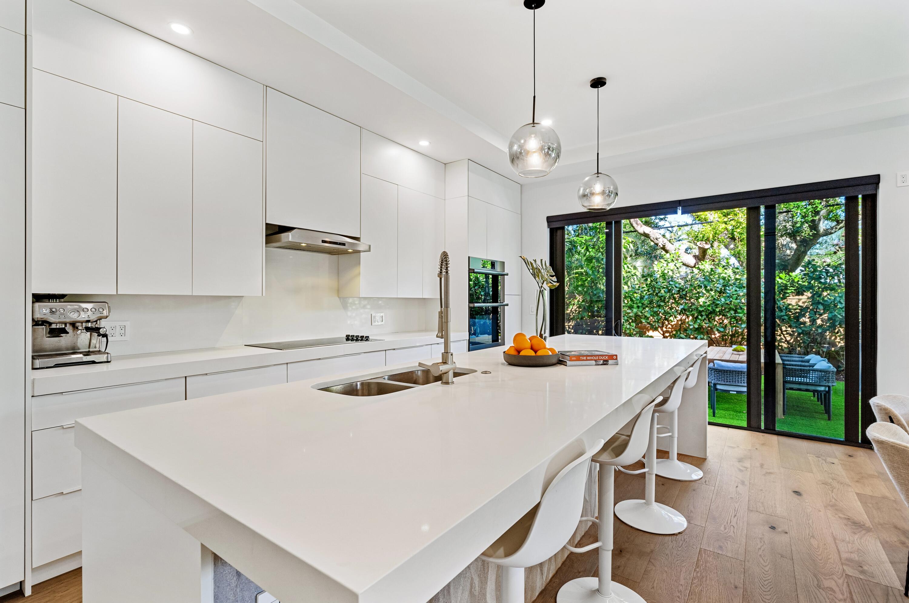 709 Northwest 6th Drive Boca Raton, FL 33486 - Photo 8 of 45 a kitchen with a stove a sink a center island and windows